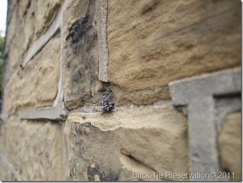 Hard cement 'strap' pointing, on a soft sandstone wall. This is causing stone erosion as water is trapped and is forced to evaporate through the stone around the edges, causing permanent damage.