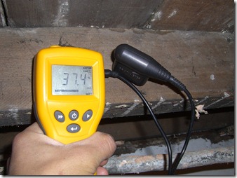 moisture meter testing a floor joist.