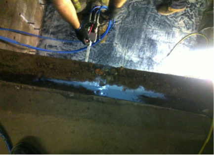 This picture shows the blue liquid which is a hydro structure resin being injected into the cavity around a lift pit. This shows how the pit is encapsulated in a waterproof coating